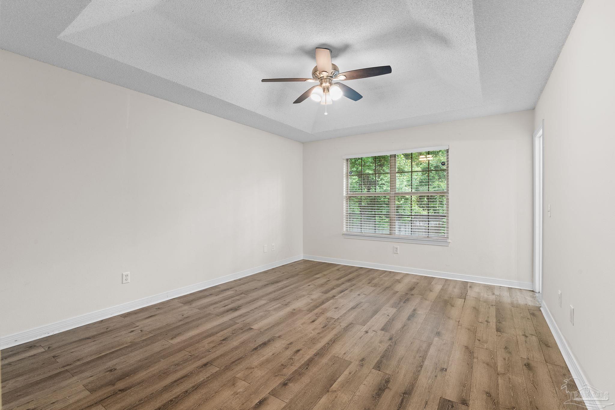 1203 Brook Bend Road Pensacola, FL 32506 - Photo 7 of 17 a view of an empty room with wooden floor and a window