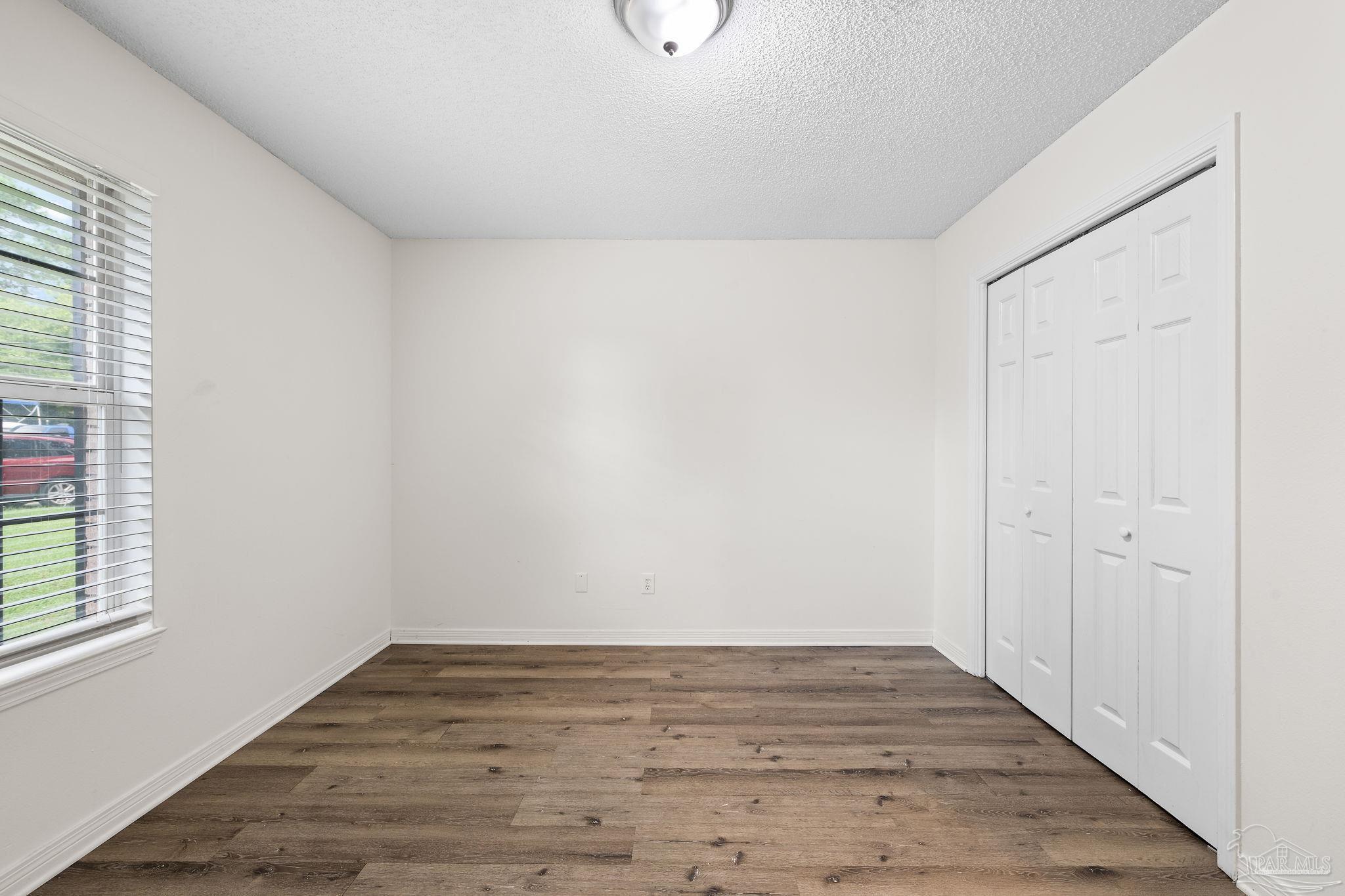 1203 Brook Bend Road Pensacola, FL 32506 - Photo 10 of 17 a view of an empty room with wooden floor and a window