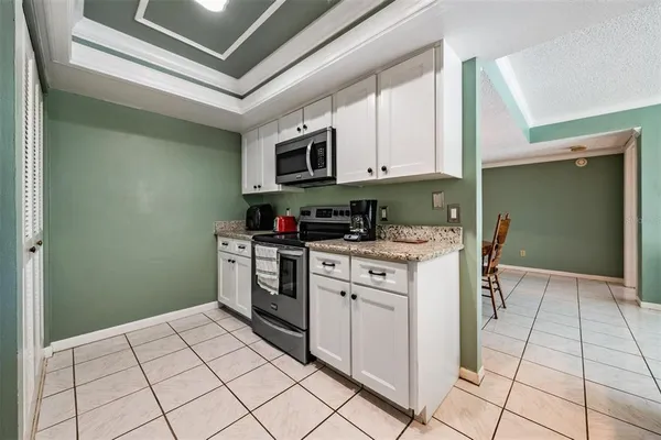 a kitchen with stainless steel appliances granite countertop a stove a sink and a microwave