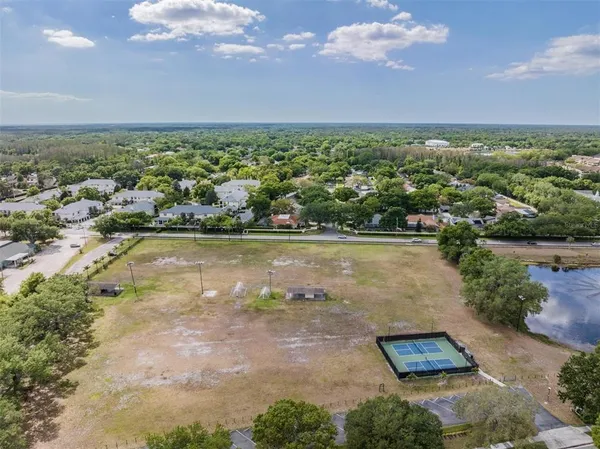 an aerial view of residential houses with outdoor space and lake view