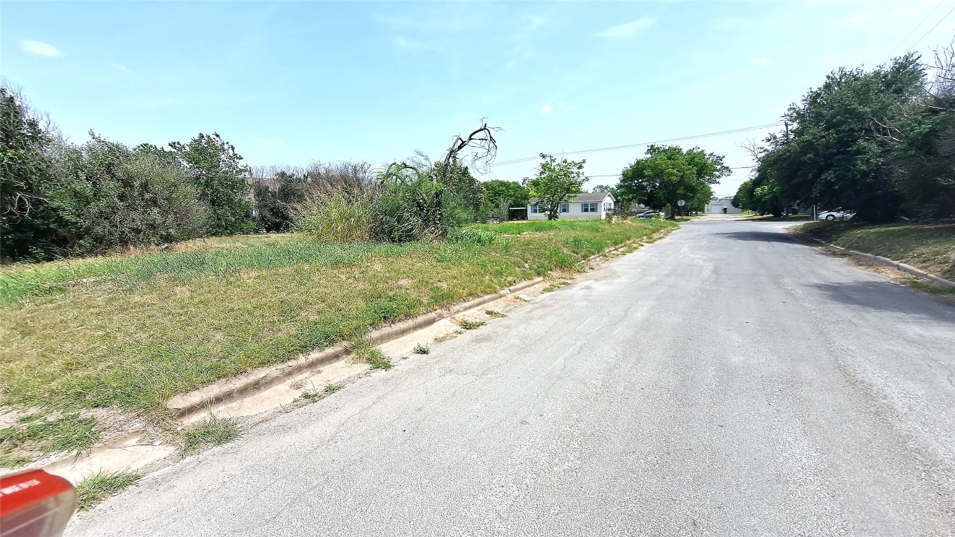 318 Burkett Street Taylor, TX 76574 - Photo 2 of 5 a view of a road with a yard and large trees