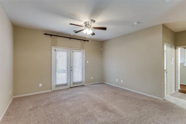 an empty room with closet and a ceiling fan