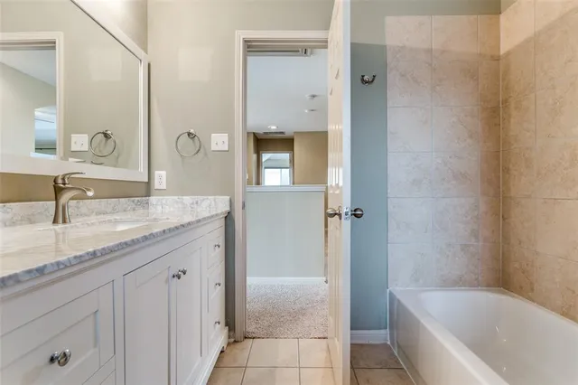a bathroom with a granite countertop sink mirror and bathtub