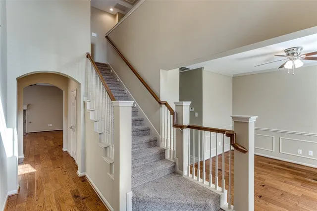 a view of a hallway with wooden floor and staircase