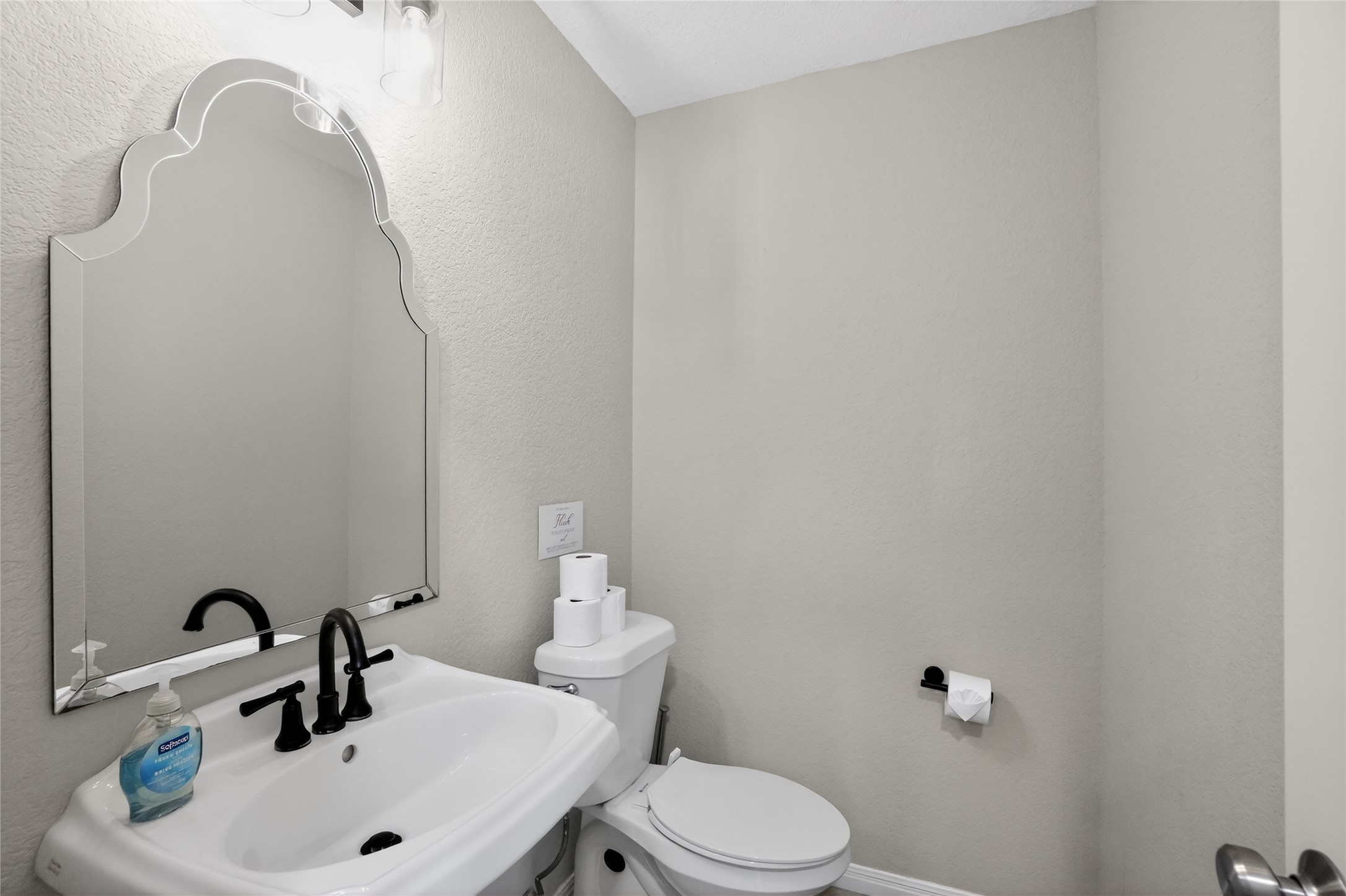 13624 Trautwein Road Austin, TX 78737 - Photo 25 of 38 A compact and well-appointed half-bathroom featuring a stylish pedestal sink and a decorative mirror.