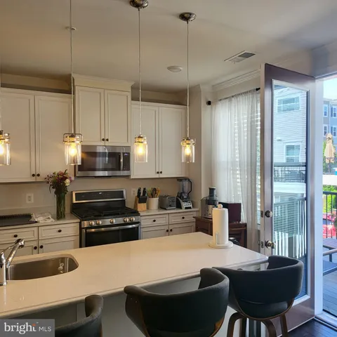 a kitchen with kitchen island granite countertop a sink stainless steel appliances and white cabinets