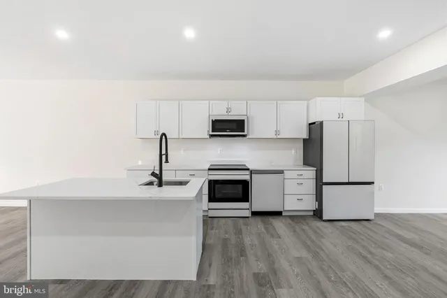 a kitchen with a sink a stove top oven and refrigerator