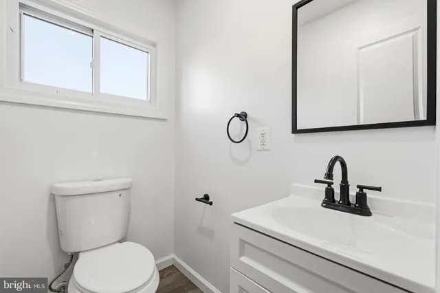 a bathroom with a toilet a sink and mirror