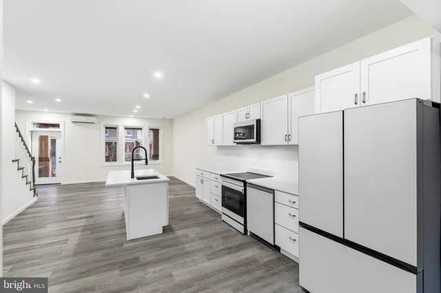a kitchen with stainless steel appliances a refrigerator sink and cabinets