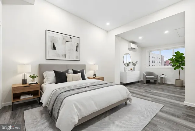 a spacious bedroom with a bed a couch and potted plant