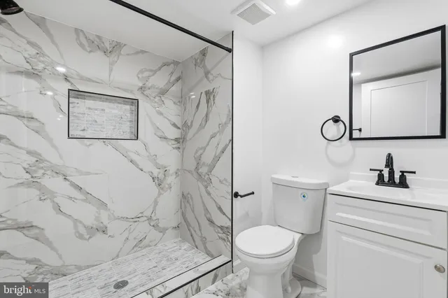 a white toilet sitting next to a bathroom sink