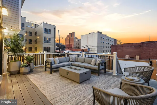 a roof deck with couches and wooden floor