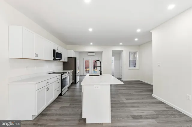 a kitchen with stainless steel appliances granite countertop a sink and a stove top oven