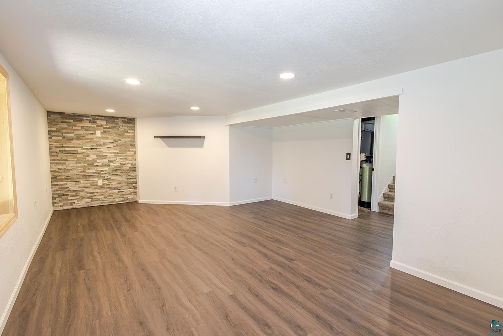 29 Ridge Road Esko, MN 55733 - Photo 28 of 41 Spacious finished room featuring wood-finish flooring, recessed lighting, and a prominent accent wall with stacked stone detailing