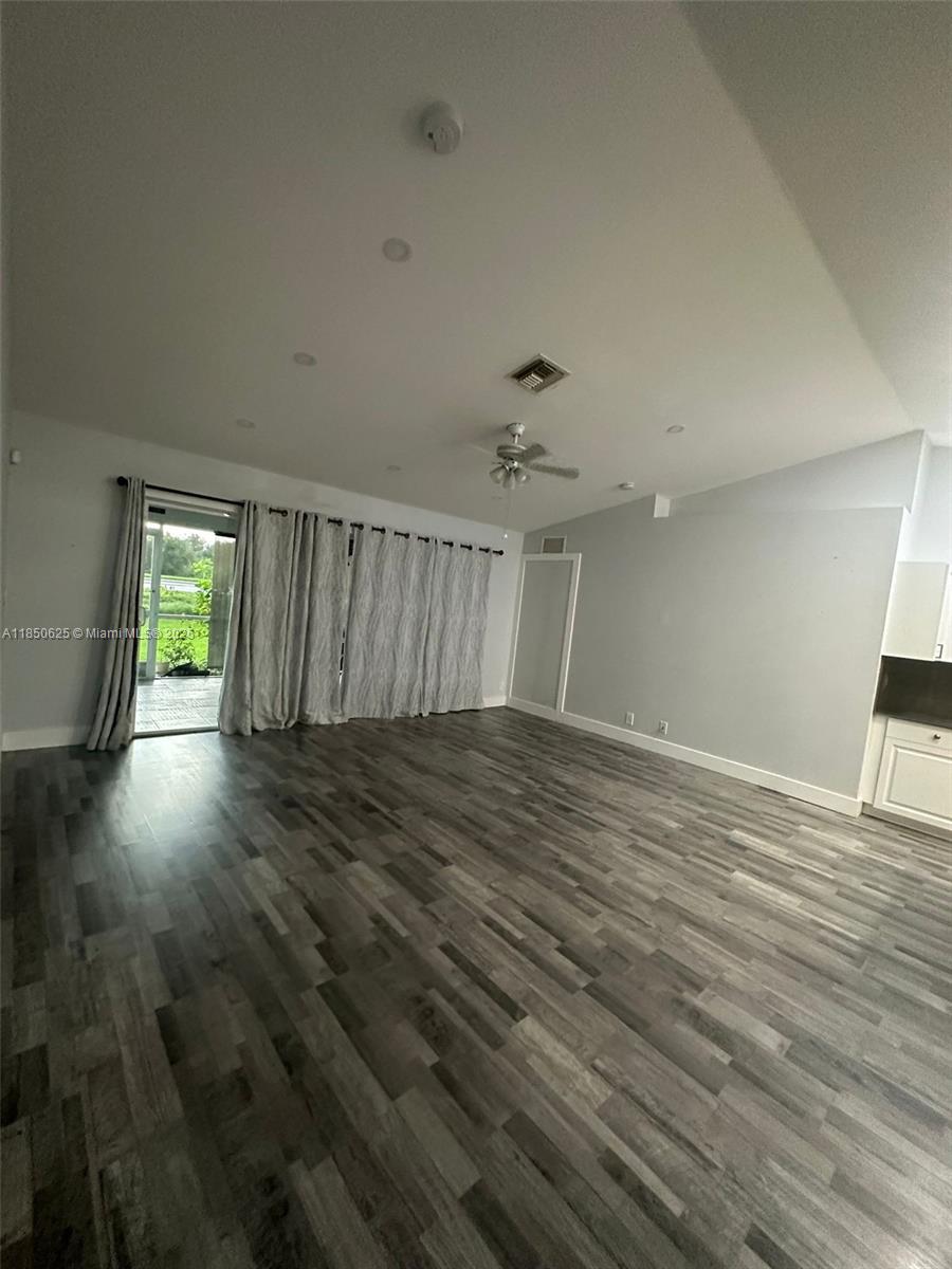 442 Conlee Street Lehigh Acres, FL 33974 - Photo 14 of 79 an empty room with wooden floor and windows