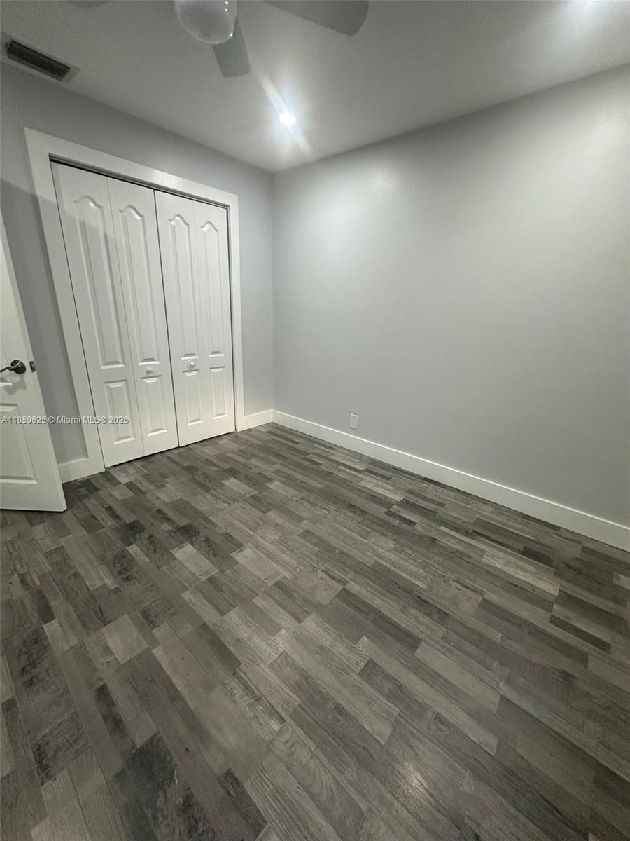 442 Conlee Street Lehigh Acres, FL 33974 - Photo 20 of 79 an empty room with wooden floor and windows