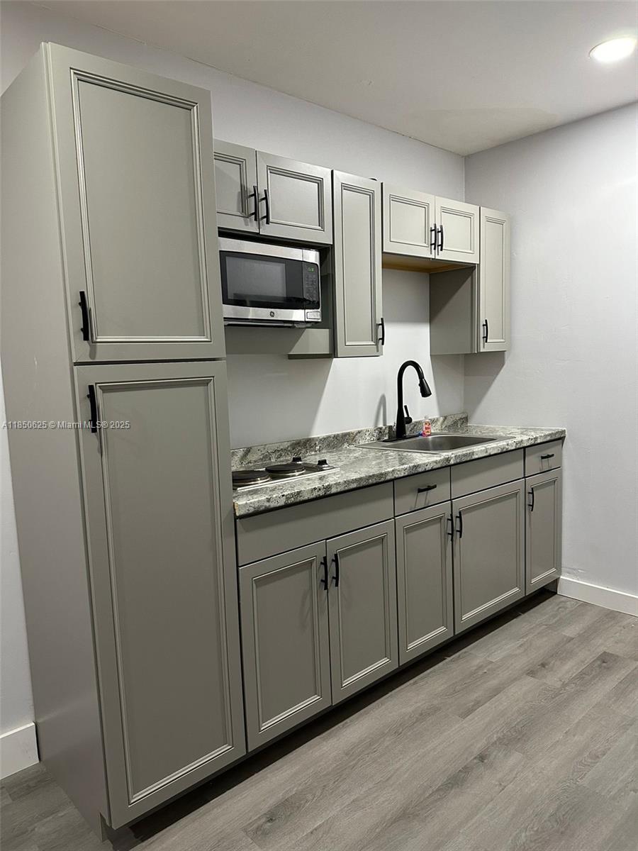 442 Conlee Street Lehigh Acres, FL 33974 - Photo 50 of 79 a kitchen with appliances a sink and cabinets