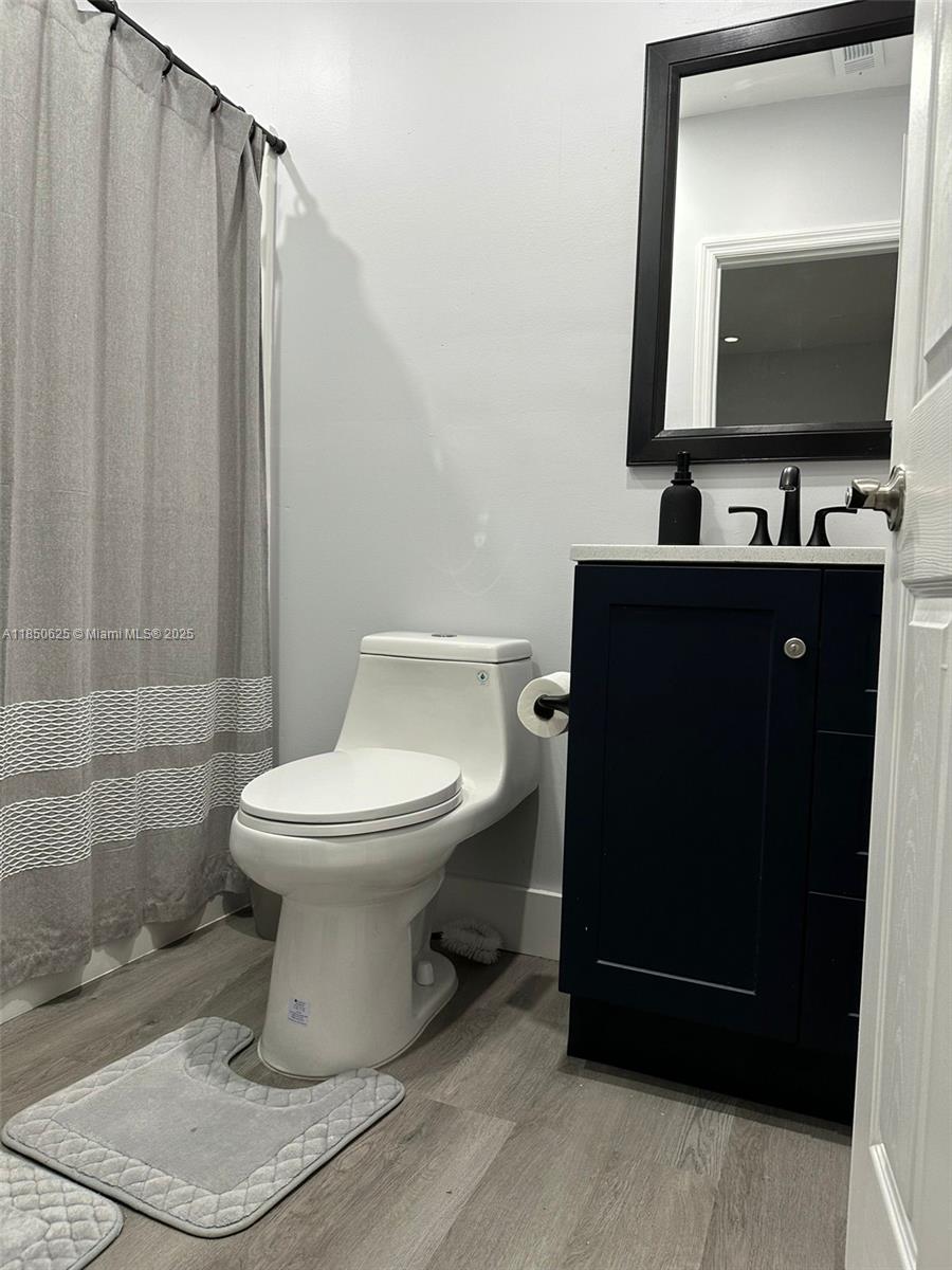 442 Conlee Street Lehigh Acres, FL 33974 - Photo 55 of 79 a bathroom with a toilet a sink and mirror