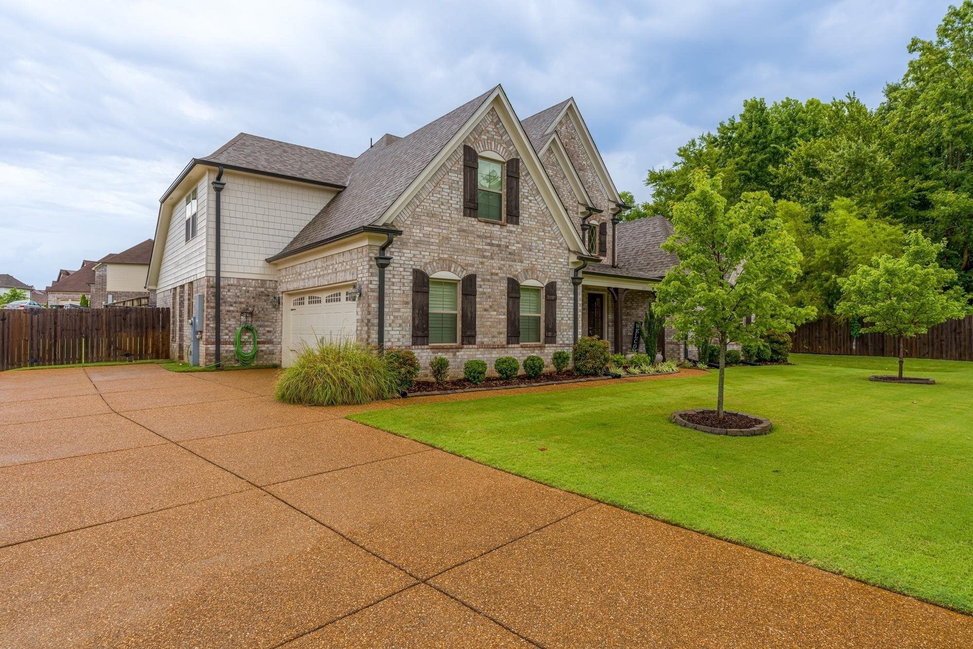 1217 Pilgrim Ridge Road Collierville, TN 38017 - Photo 3 of 33 View of front facade featuring roof with shingles, brick siding, concrete driveway, a garage, and covered porch