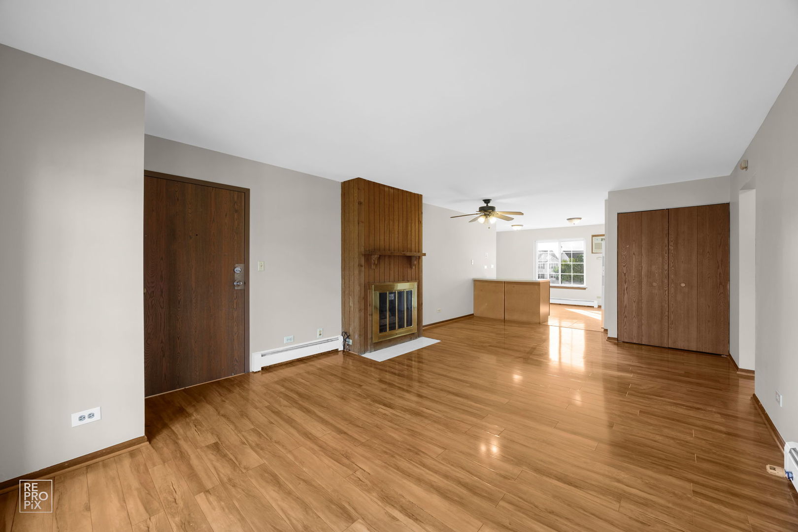 2300 Century Point Lane, Unit F Glendale Heights, IL 60139 - Photo 4 of 10 a view of a livingroom with a fireplace a ceiling fan and wooden floor