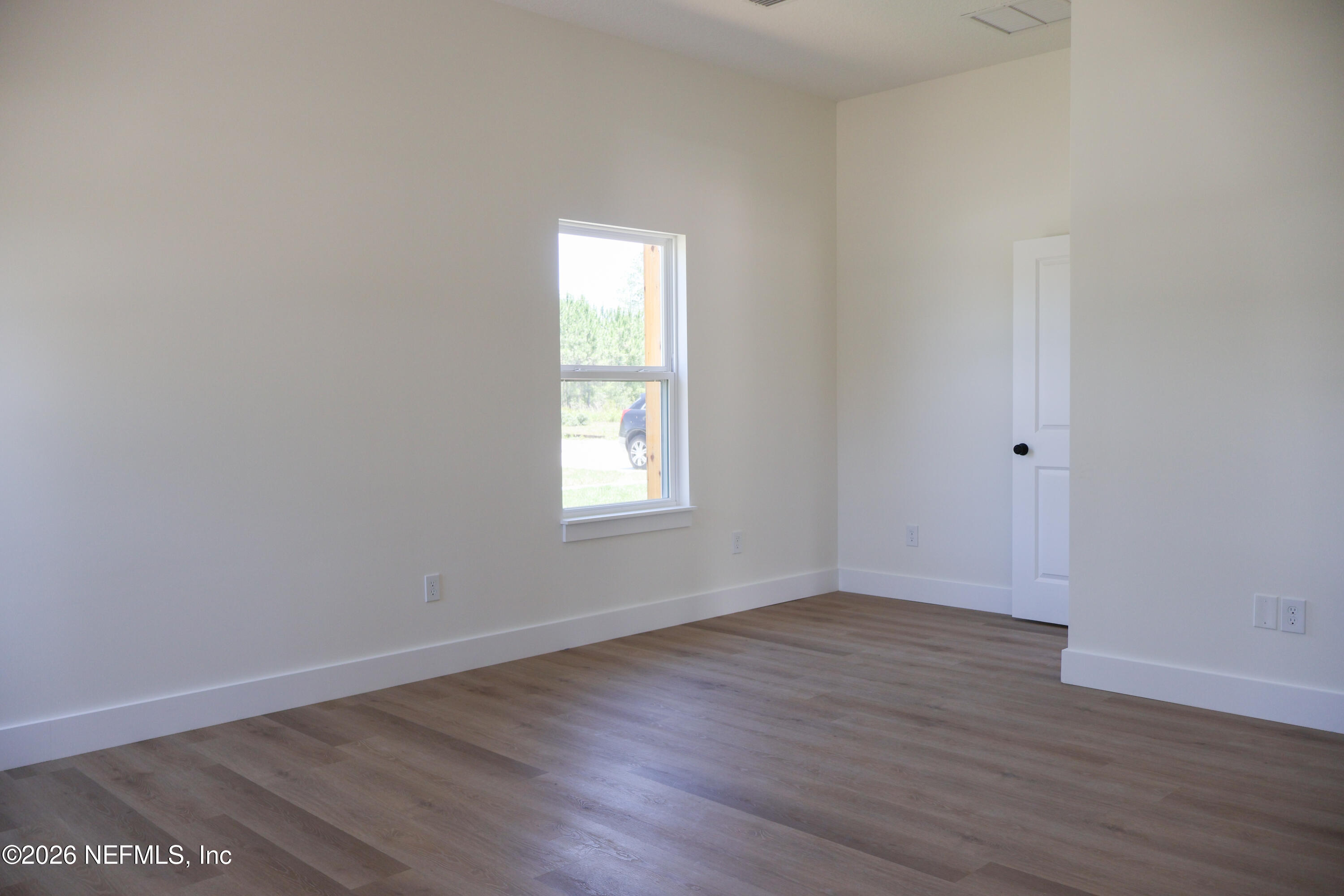 261121 Rowe Road Hilliard, FL 32046 - Photo 17 of 33 an empty room with wooden floor and windows