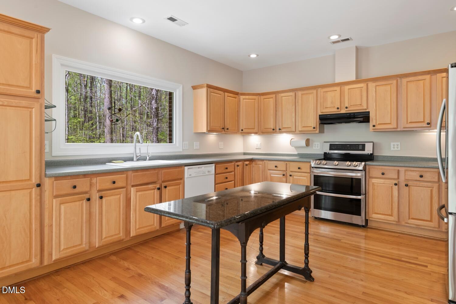4524 Ridge Trail Efland, NC 27243 - Photo 20 of 48 a kitchen with granite countertop a stove a sink dishwasher a microwave oven with a dining table and chairs with wooden floor