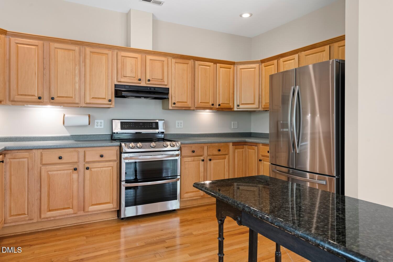 4524 Ridge Trail Efland, NC 27243 - Photo 22 of 48 a kitchen with granite countertop a refrigerator stove and sink with wooden floor