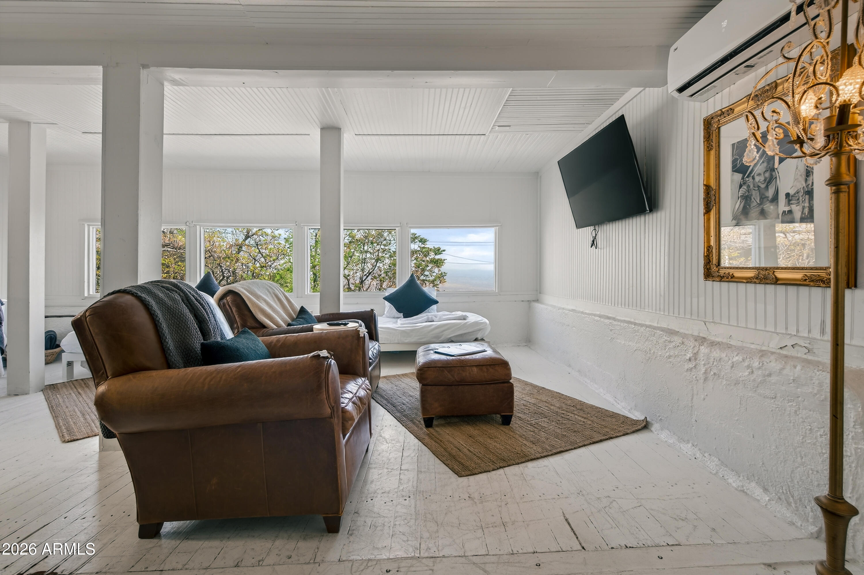 511 Main Street Jerome, AZ 86331 - Photo 19 of 67 a living room with furniture a flat screen tv and a floor to ceiling window