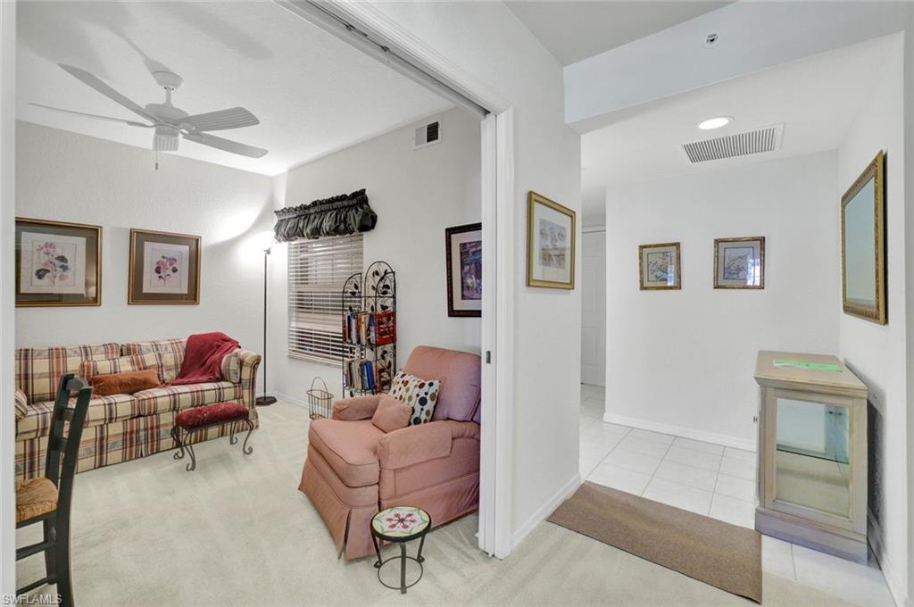 6883 Redbay Park Road, Unit 102 Naples, FL 34109 - Photo 6 of 22 a living room with furniture and a flat screen tv