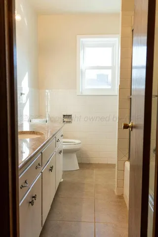 a en suite bathroom with a granite countertop sink and a mirror