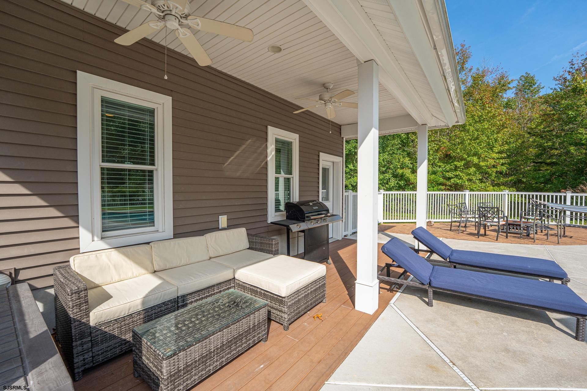 103 Tyler Road Ocean View, NJ 08230 - Photo 40 of 80 a view of a patio with couches table and chairs with wooden floor and fence