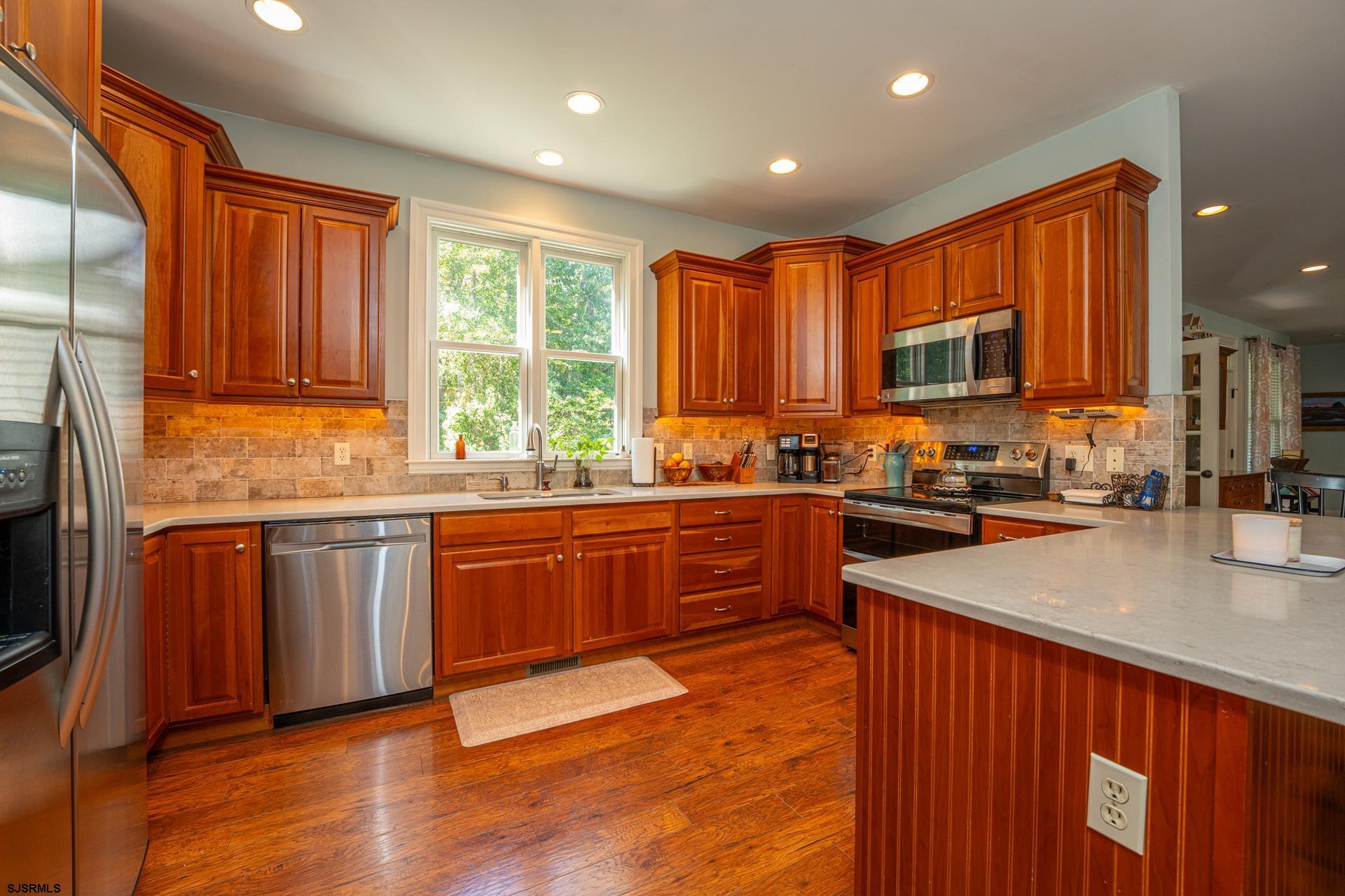 103 Tyler Road Ocean View, NJ 08230 - Photo 46 of 80 a kitchen with stainless steel appliances granite countertop wooden cabinets a sink and a stove