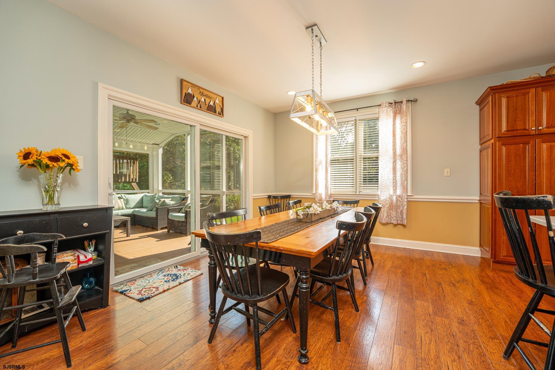 103 Tyler Road Ocean View, NJ 08230 - Photo 48 of 80 a dining room with furniture a chandelier and wooden floor