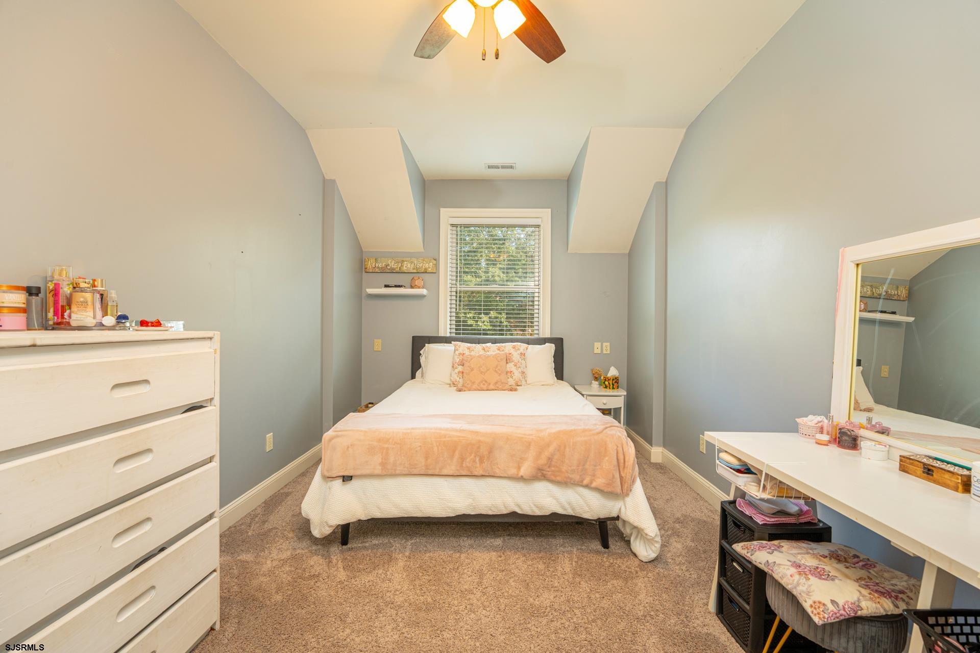 103 Tyler Road Ocean View, NJ 08230 - Photo 66 of 80 a bedroom with a bed and a chandelier