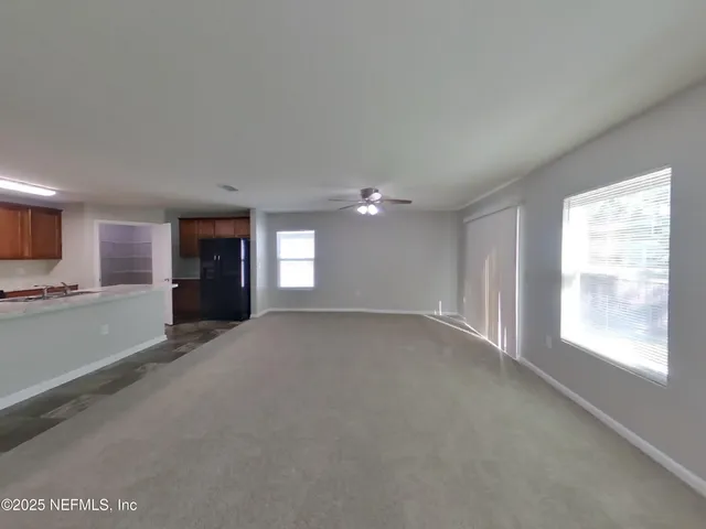 a view of empty room with a window and fireplace