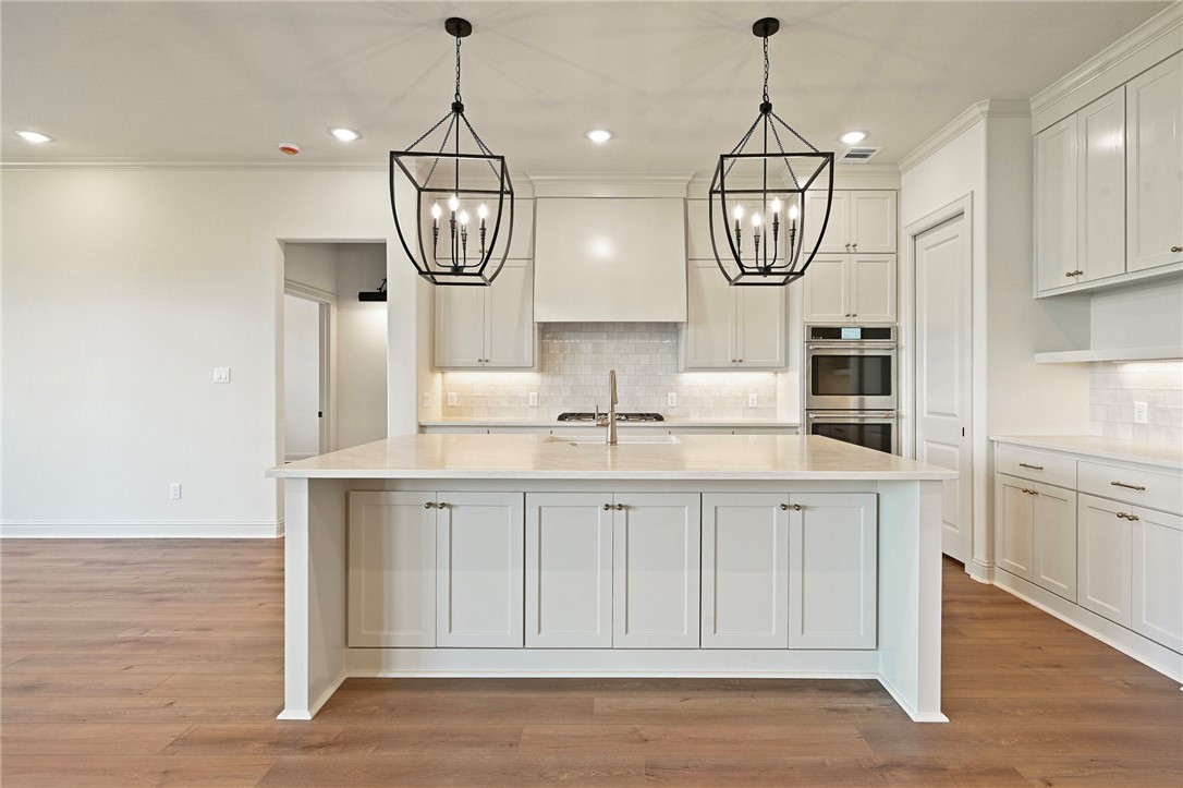 7052 Skipping Rock Path Bryan, TX 77808 - Photo 6 of 23 a kitchen with white cabinets and wooden floor