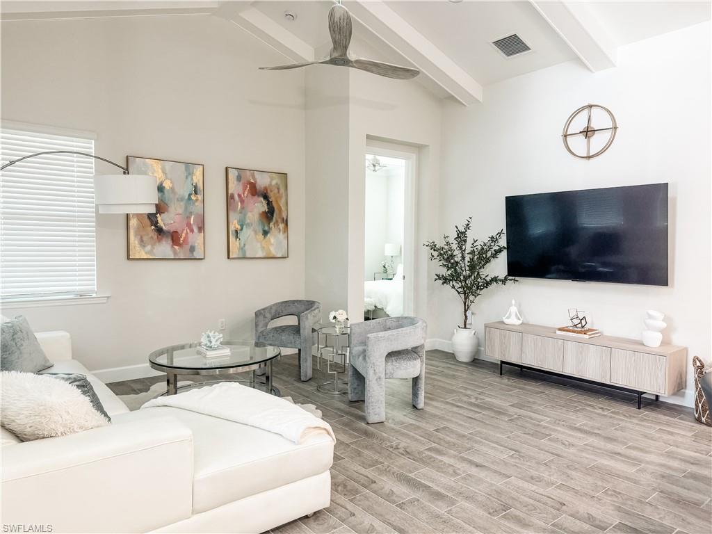 7289 Saona Court Naples, FL 34113 - Photo 2 of 17 a living room with furniture and a flat screen tv