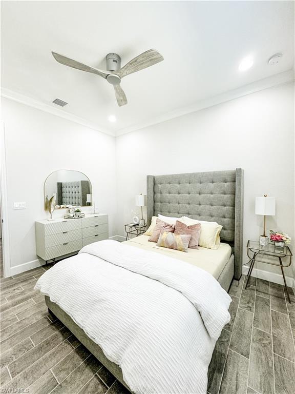 7289 Saona Court Naples, FL 34113 - Photo 9 of 17 a bedroom with a bed and ceiling fan