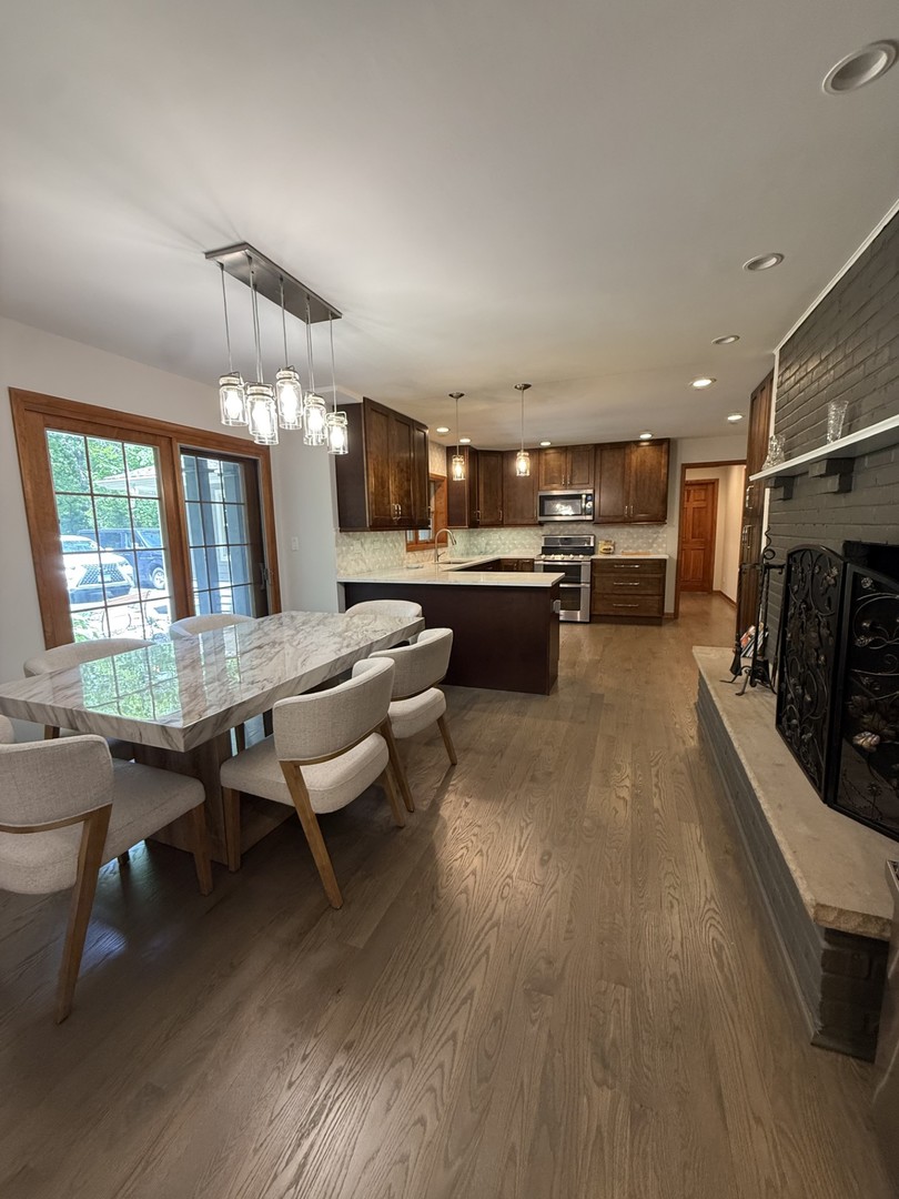 2841 Orange Brace Road Deerfield, IL 60015 - Photo 4 of 30 a kitchen with a sink dishwasher a dining table and chairs with wooden floor