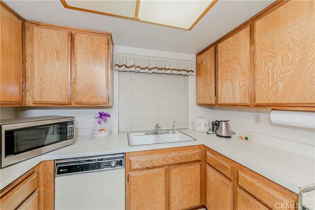 a kitchen with stainless steel appliances granite countertop a stove top oven a sink a counter space and cabinets