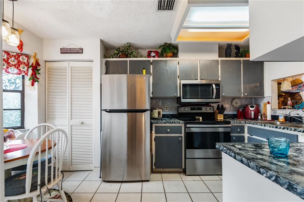 11719 Rose Tree Drive New Port Richey, FL 34654 - Photo 12 of 51 a kitchen with stainless steel appliances granite countertop a refrigerator and a stove
