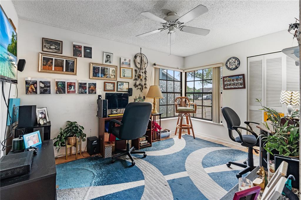 11719 Rose Tree Drive New Port Richey, FL 34654 - Photo 16 of 51 a living room with furniture a piano and a bookshelf