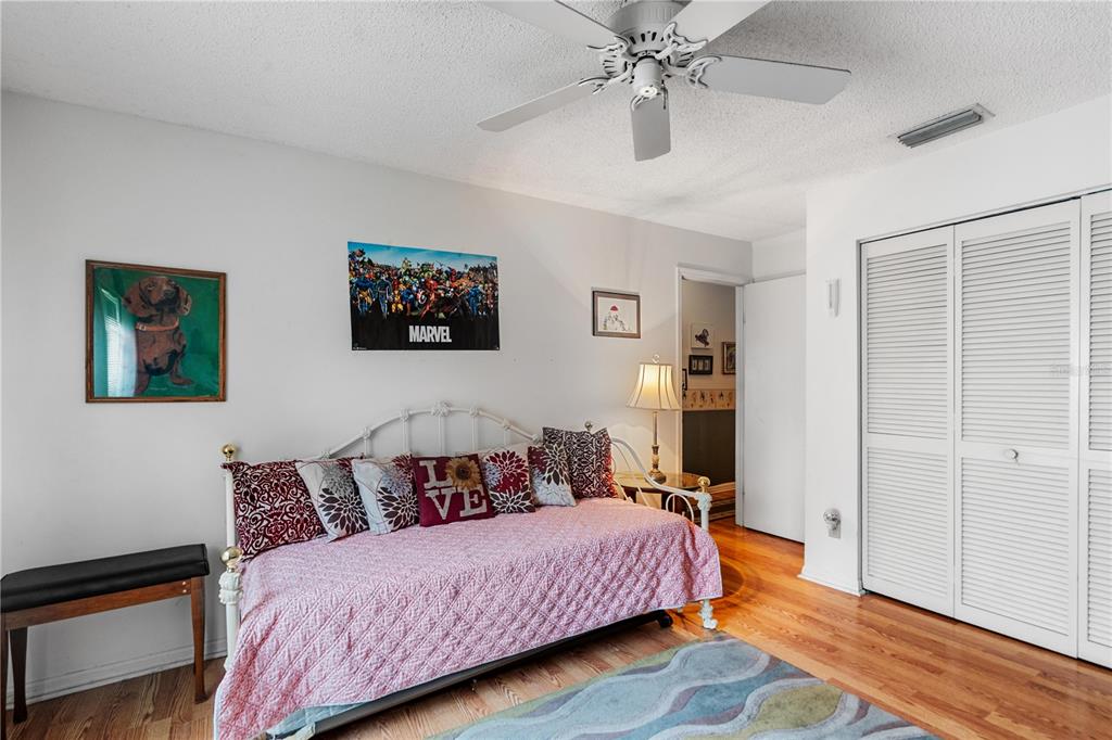 11719 Rose Tree Drive New Port Richey, FL 34654 - Photo 21 of 51 a bedroom with a bed and wooden floor