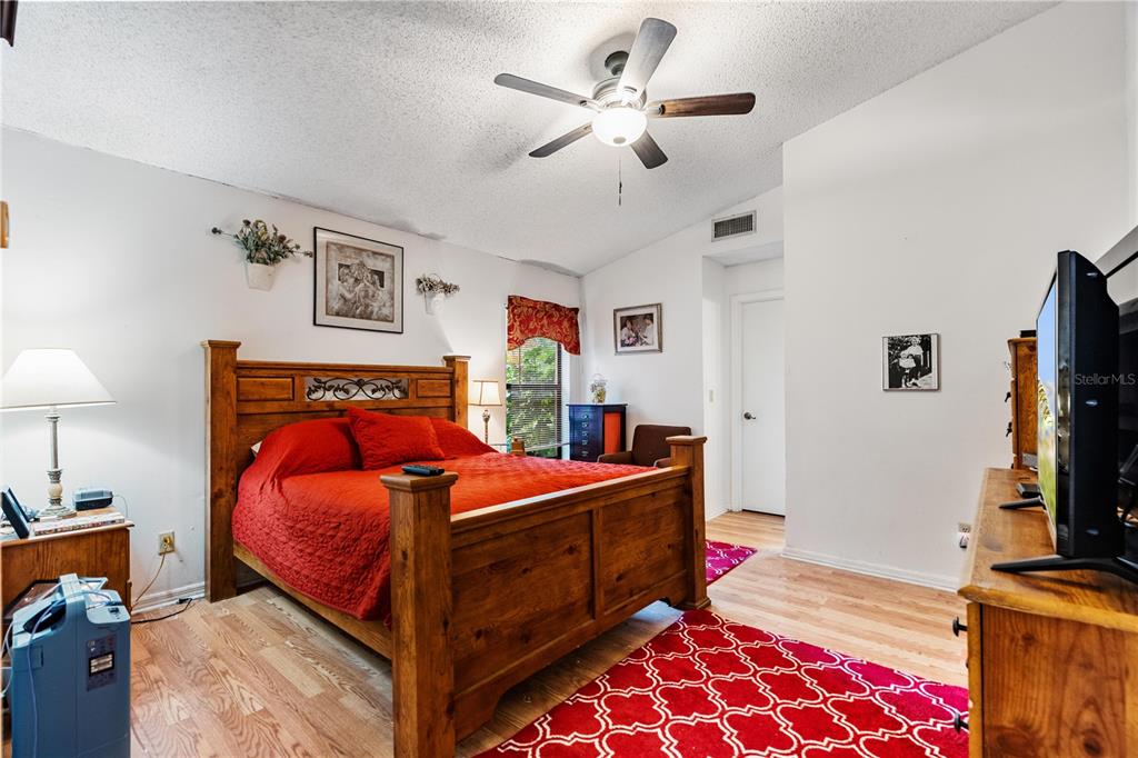 11719 Rose Tree Drive New Port Richey, FL 34654 - Photo 23 of 51 a bedroom with a bed and a flat screen tv