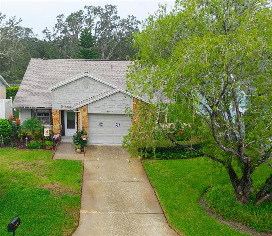 11719 Rose Tree Drive New Port Richey, FL 34654 - Photo 3 of 51 a front view of a house with garden