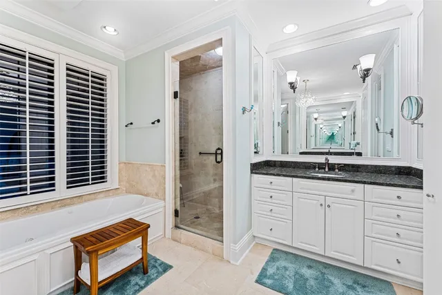 a spacious bathroom with a granite countertop sink a mirror a shower and a bathtub
