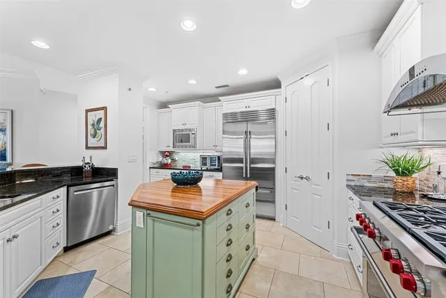 a kitchen with stainless steel appliances granite countertop a stove a sink and a refrigerator