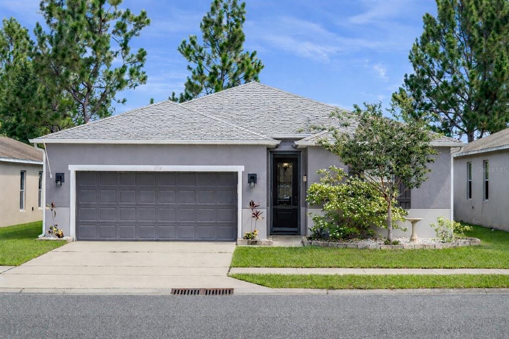 a front view of a house with a garden and garage