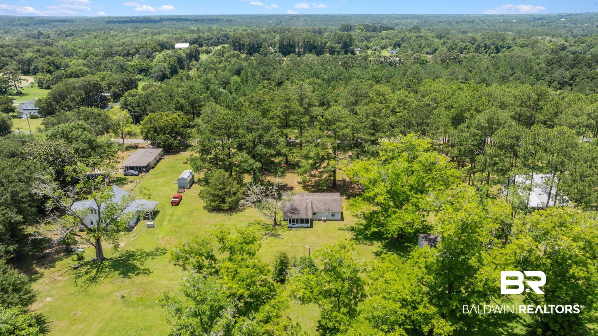20540 Lacey Road Silverhill, AL 36576 - Photo 35 of 40 Expansive wooded property featuring a single-story residence with a light-colored exterior and a dark roof