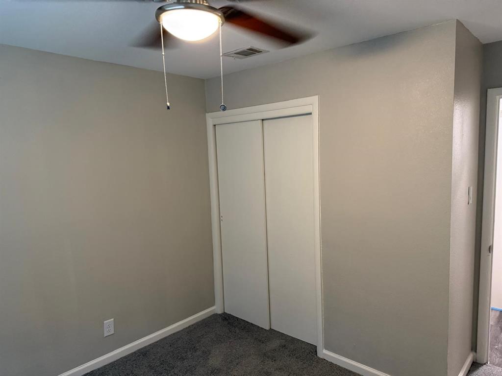 925 Bluewood Drive Dallas, TX 75232 - Photo 13 of 33 Unfurnished bedroom with dark carpet, a closet, and ceiling fan